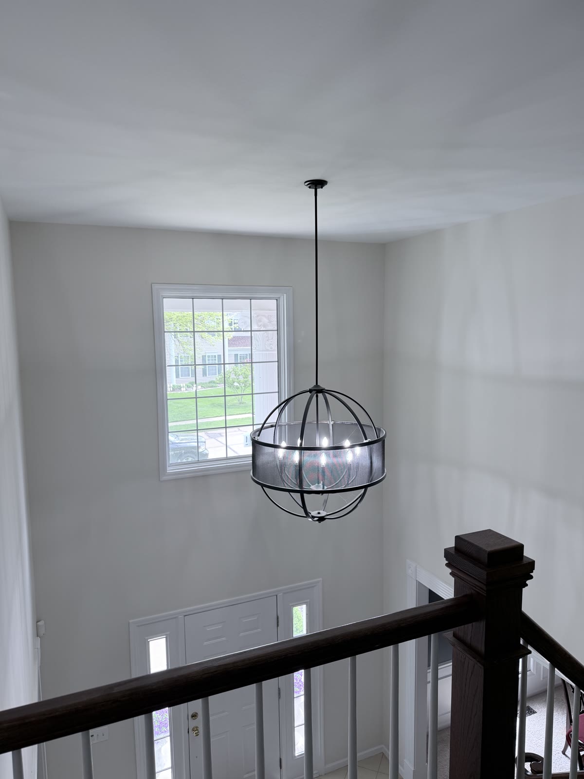 Two-story foyer with fresh paint and pendant light