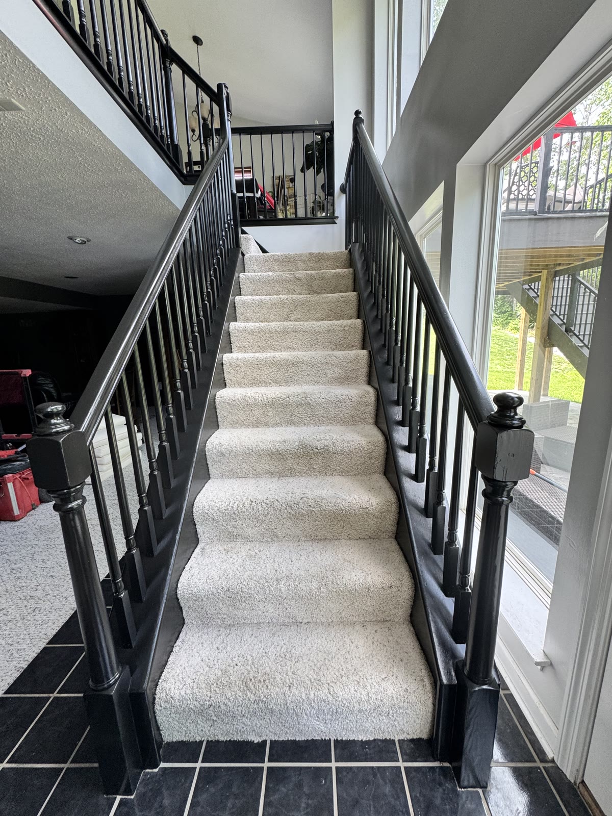 Black iron stair railing with carpet treads